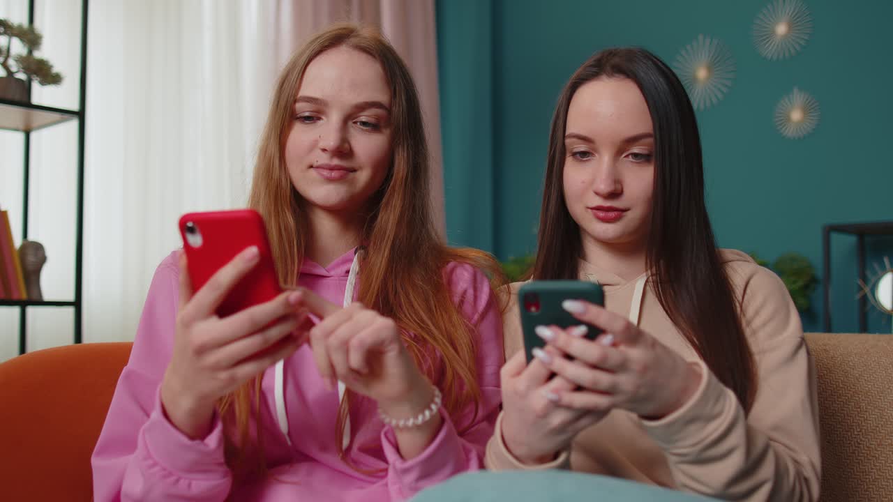 Amiche, sorelle festeggiano la vittoria e urlano di gioia mentre fanno shopping online sullo smartphone