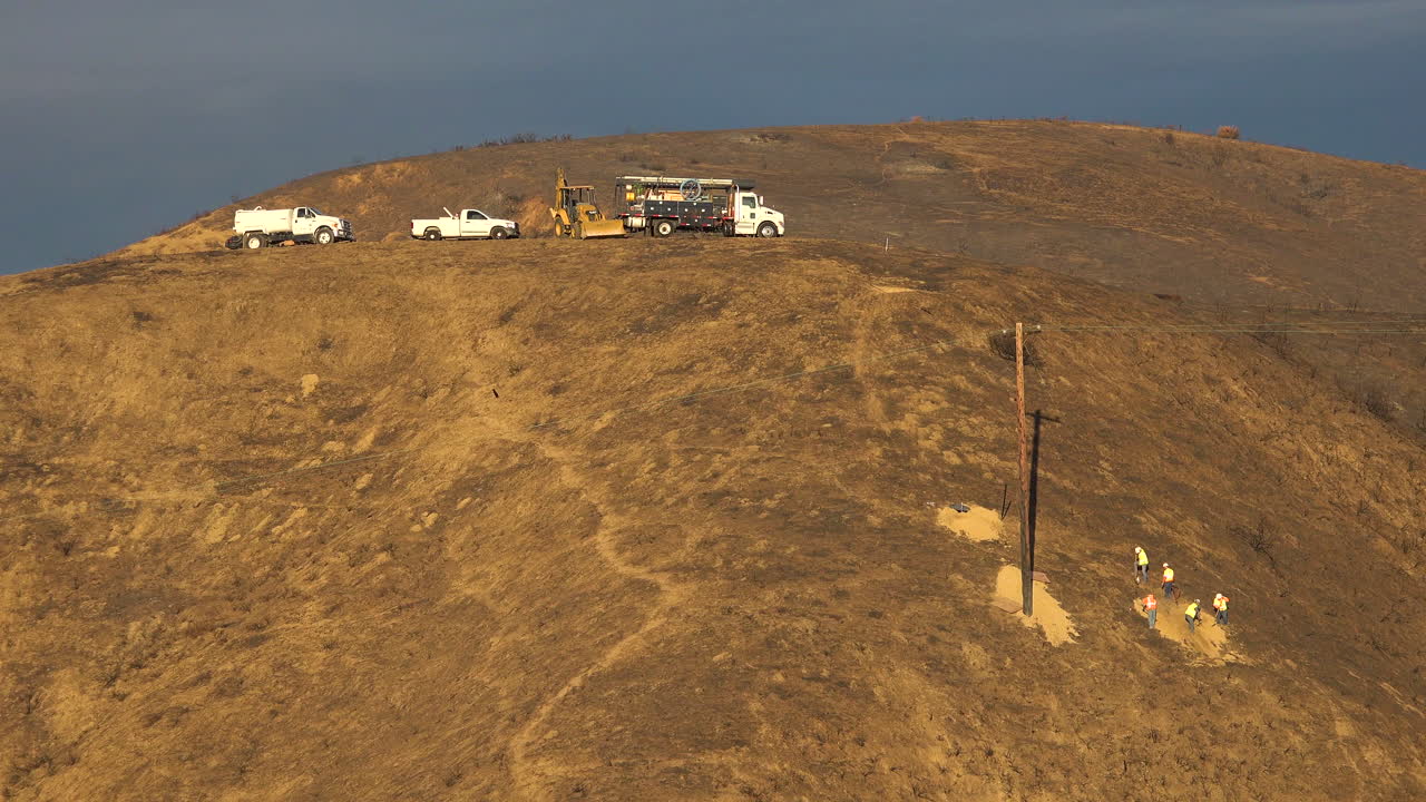 sce 전화 라인맨 유지 보수 승무원은 비참한 토마스 화재 이후 불타버린 언덕의 전력선에서 작업합니다.