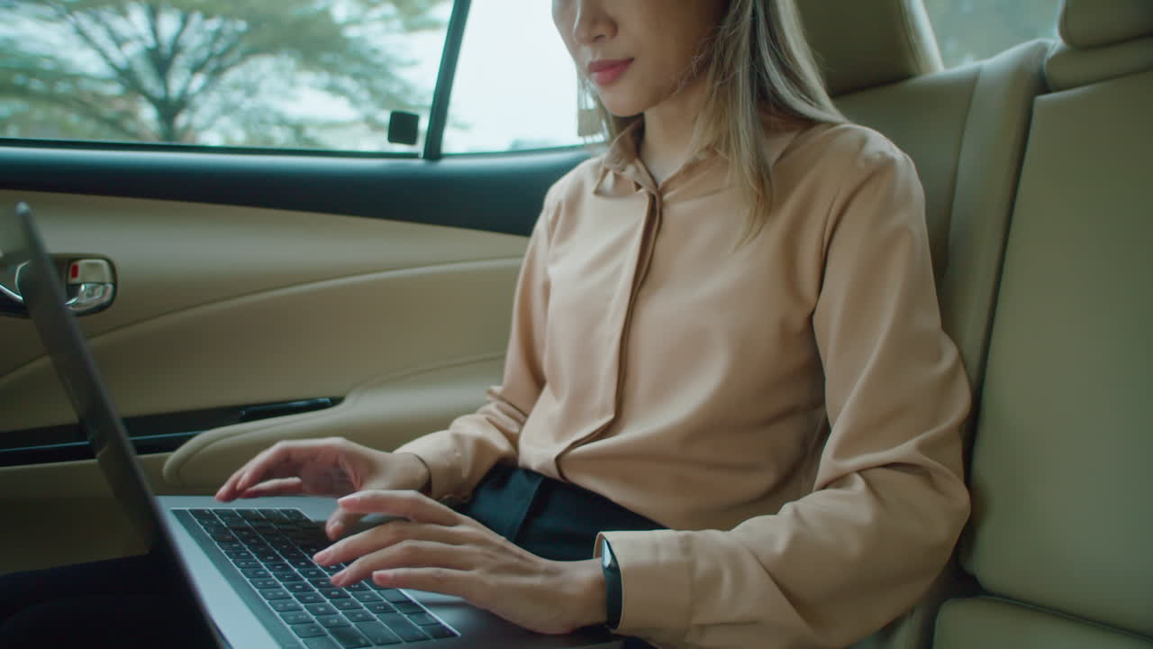 Businesswoman Using Laptop during Taxi Ride