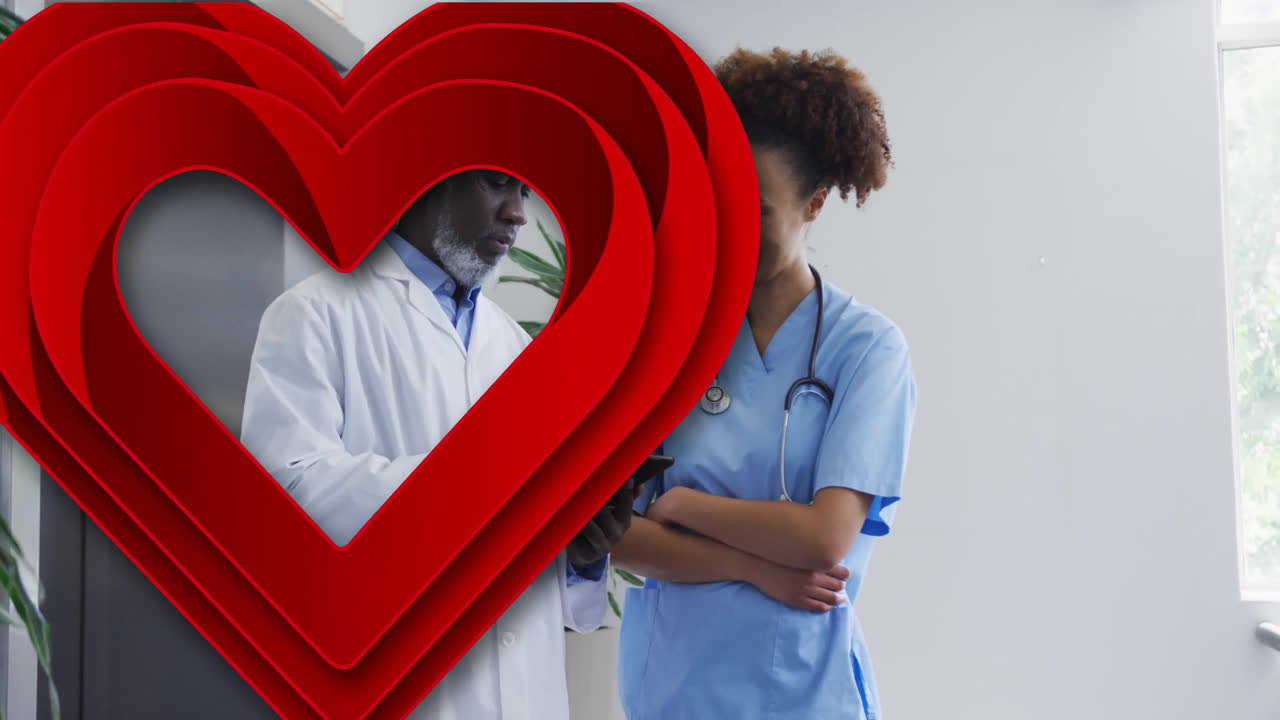 Zdravotníci projednávající informace o pacientovi s animací srdce v nemocnici.