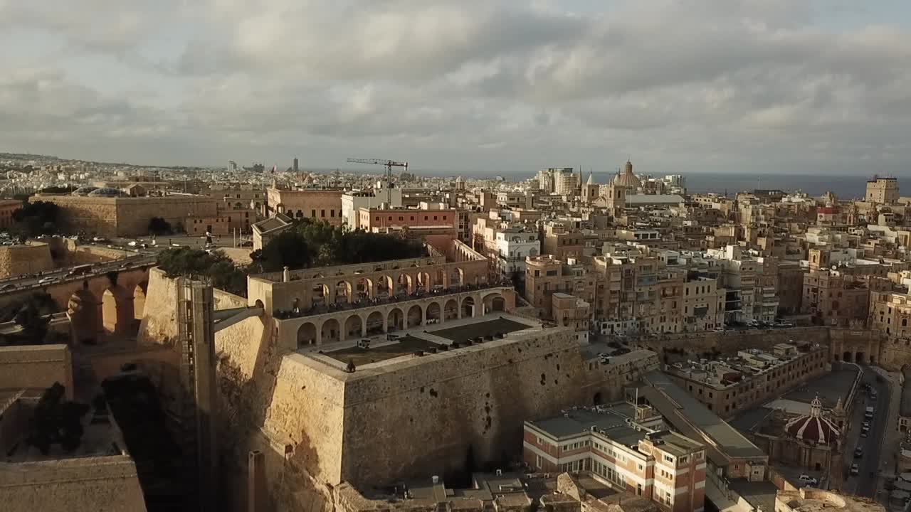 Aerial view of the saluting battery and upper Barrakka gardens of Valetta, Malta, Europe. Dolly shot, pulling away from the saluting battery, revealing Valetta.