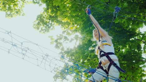 a brave child walks along a tightrope between tall trees active childhood and fun