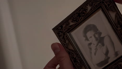 holding a vintage photo of a woman