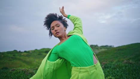 emotional woman performing dance on green grass field closeup. girl dancing
