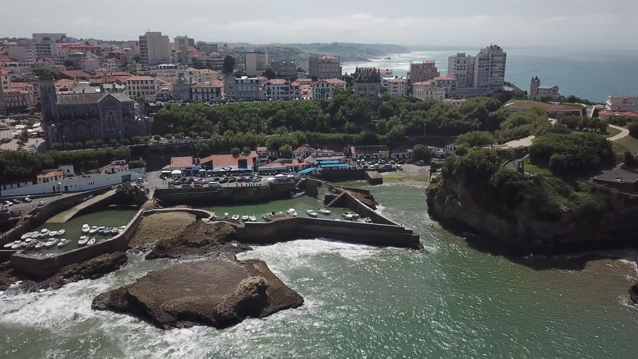 Storico Port des Pêcheurs a Biarritz, barche nel porto e skyline della città sullo sfondo, Costa Basca francese, Francia. Vista panoramica aerea con drone