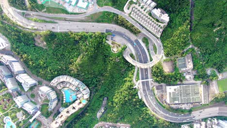 Hong-Kong-express-highway-traffic-with-Residential-buildings-and-green-nature-surroundings,-Aerial-view