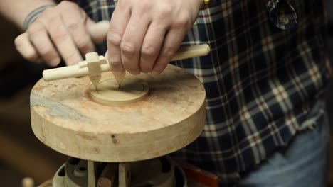 a potter cuts a circle of clay with a compass