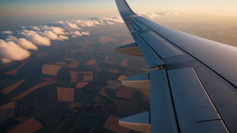airplane view of clouds and landscape at sunset