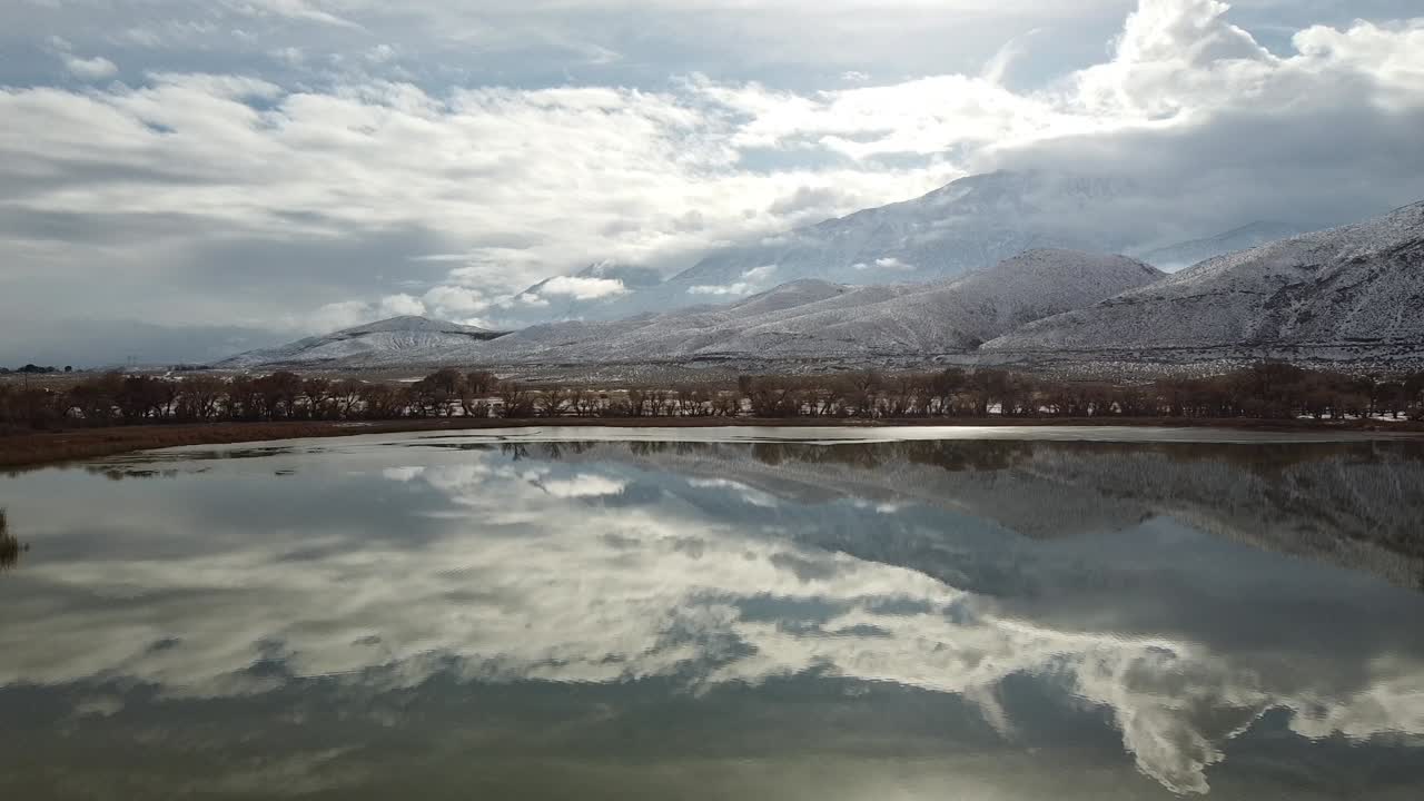 lago diaz y valle de owens en un día nublado de invierno, california estados unidos, naturaleza salvaje paisaje junto al lago con reflejo de nubes en la superficie del agua y montañas inyo en el horizonte