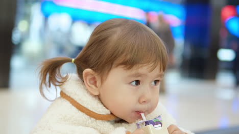 쇼핑몰에서 주스를 마시는 어린 소녀