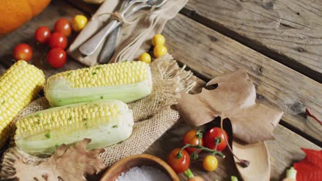 vista de cerca de múltiples ingredientes alimentarios, hojas de otoño y cubiertos en una superficie de madera