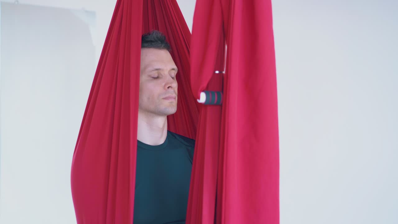 집중된 잘생긴 남자가 편안하게 앉아서 명상합니다.