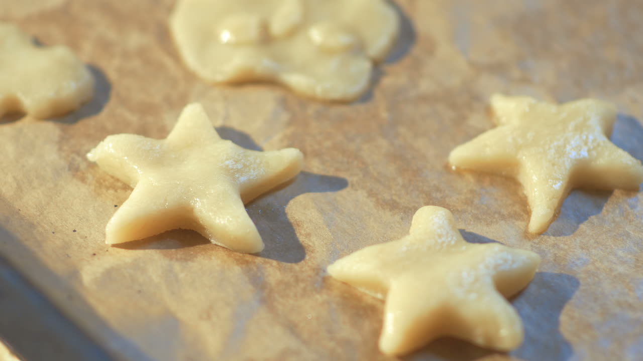 Mano di donna che posiziona l'impasto per biscotti su una teglia da forno
