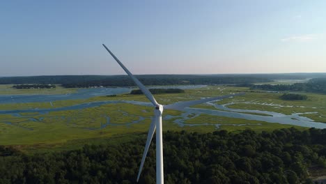 Windmill-with-ocean-and-a-marsh--filmed-with-a-drone