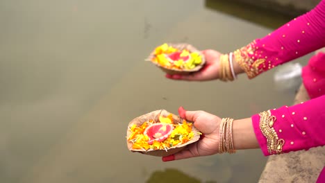 Nahaufnahme-Der-Hände-Unerkannter-Frauen,-Die-Diya-Für-Aarti-In-Der-Nähe-Von-Flusswasser-Halten,-Gebet-Für-Indische-Götter