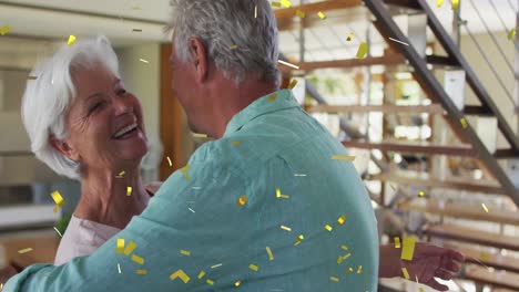 animation of gold confetti falling over happy caucasian senior couple dancing at home