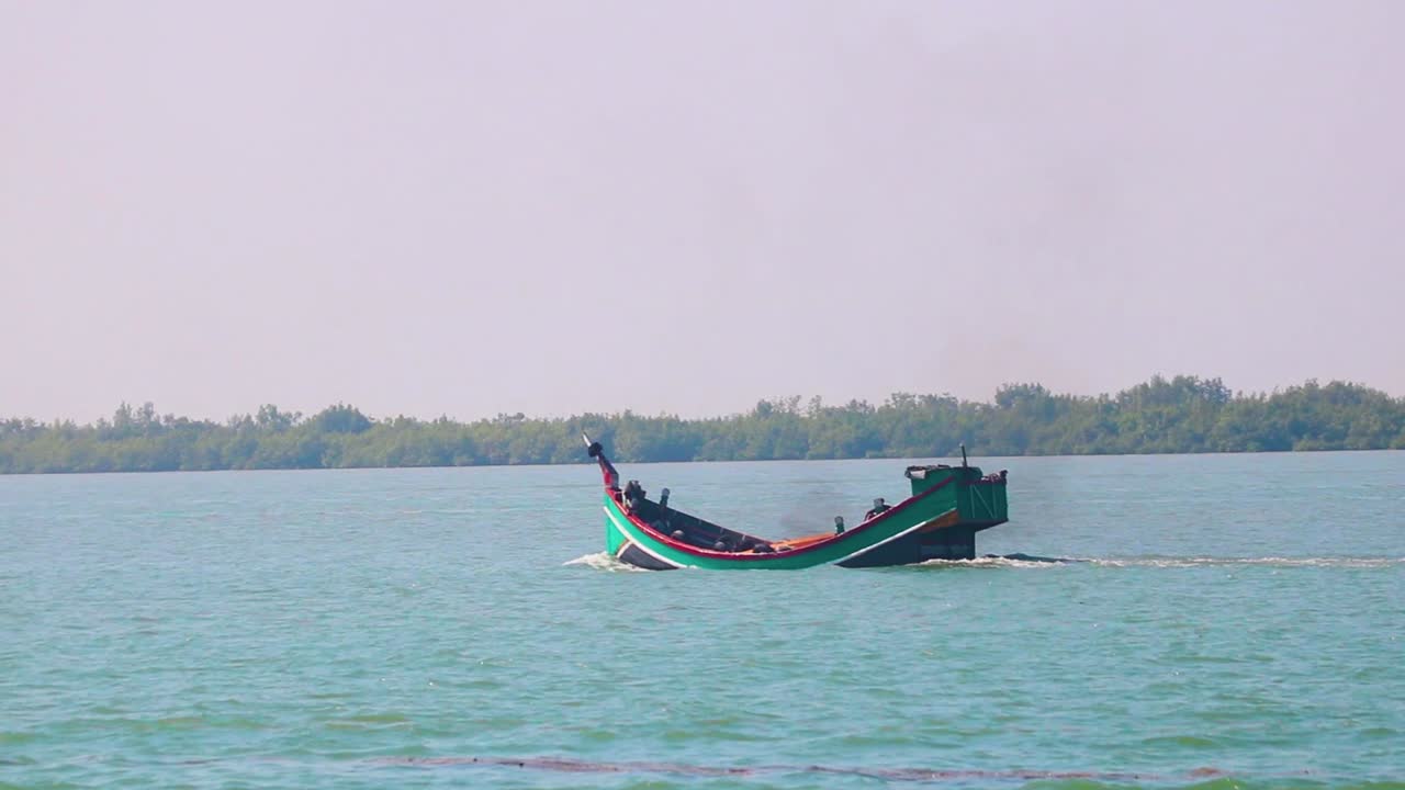 Barco sampana tradicional movendo-se no Rio Naf perto da costa da Baía de Bengala