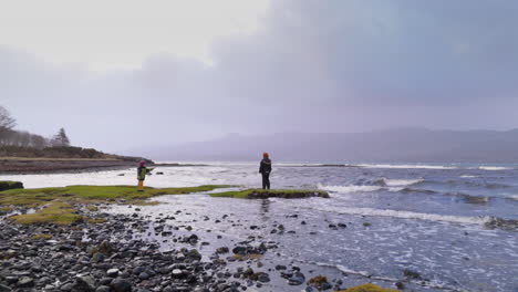 boy and girl siblings explore cobble coastline of scotland west coast, gimbal