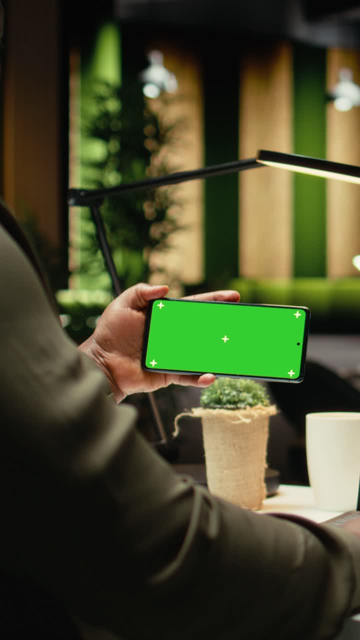 Vertical Video Green screen on smartphone at desk with black business person