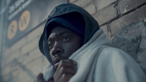 Homeless Man Wrapped in Blanket Shivering from Cold on Winter Day