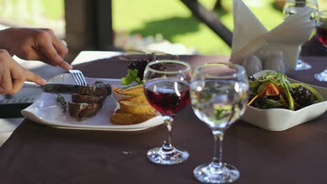 Mujer-Joven-Cortando-Y-Comiendo-Carne-Deliciosa-En-El-Café