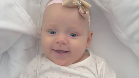 retrato de una niña sonriente de ojos azules de seis meses de edad