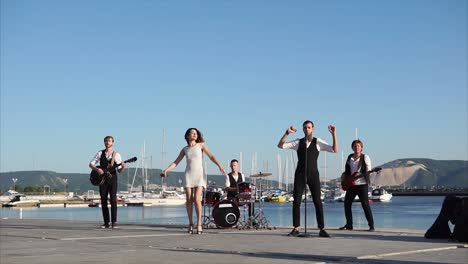 band performing live at a waterfront location