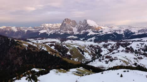 vista aérea panorámica hacia atrás de la cordillera de los dolomitas cubierta de nieve desde seiser alm - meseta alpe di siusi en tirol del sur, italia alrededor de la puesta del sol