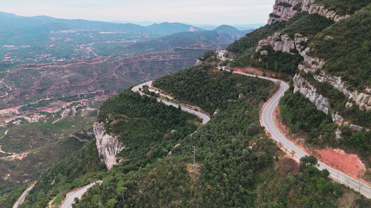 드론은 평온한 흐린 날에 스페인 그랜드 캐니언의 푸른 절벽에서 도로를 날아갑니다.