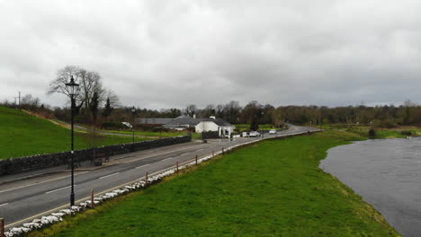 Aerial---Main-road-of-a-downtown-nearby-the-river-and-the-cafe-on-the-roadside