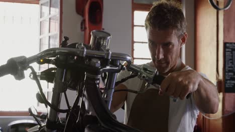 mecánico masculino reparando motocicletas en el garaje de reparación 4k