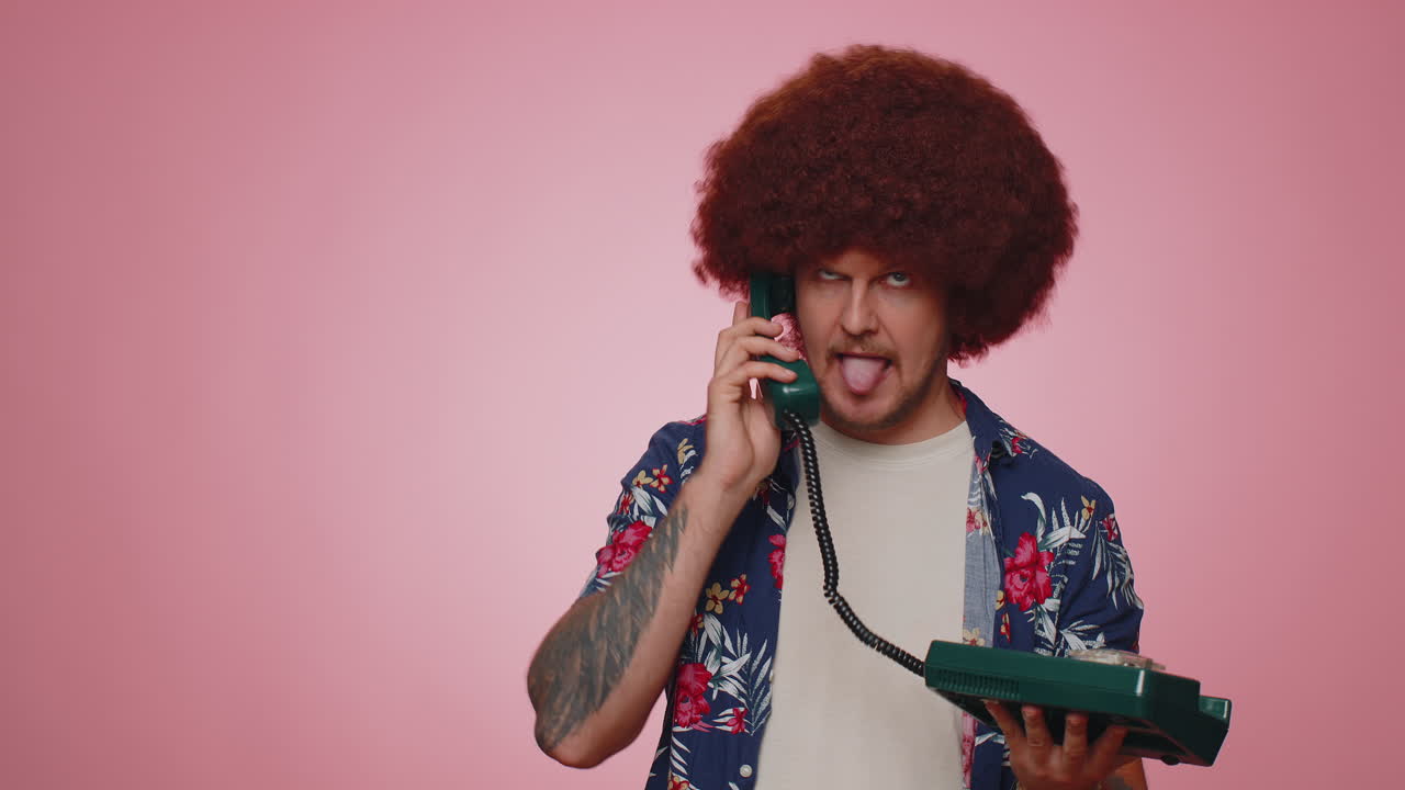 loco agente de línea directa turística hombre hablando en un teléfono vintage de los años 80 engañando haciendo caras tontas