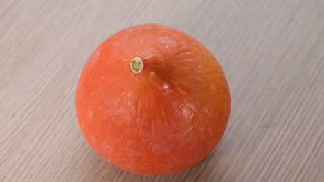 orange pumpkin rotating on wooden background