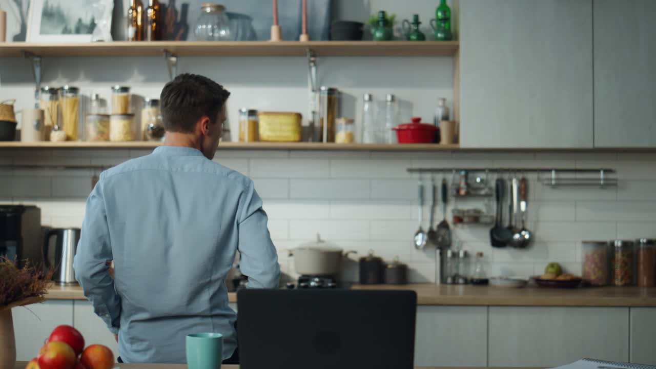 hombre girando el portátil de música en la mesa de la cocina. hombre bailando disfrutando del descanso del trabajo.