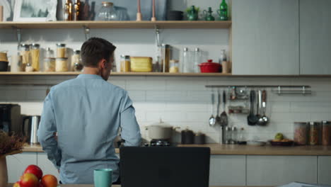 Hombre-Girando-La-Computadora-Portátil-De-Música-En-La-Mesa-De-La-Cocina.-Chico-Bailando-Disfrutando-De-Un-Descanso-Del-Trabajo.