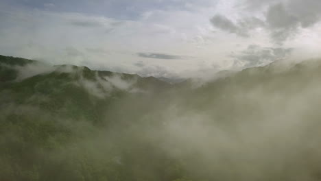 aerial view flying above lush green tropical rain forest mountain with rain cloud cover during the rainy season on the doi phuka mountain reserved national park the northern thailand