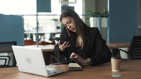 pretty woman sits determinedly in the office, working on her laptop and striving to tackle a challenging task