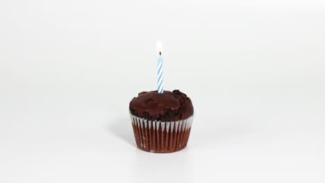 chocolate cupcake with a single lit candle