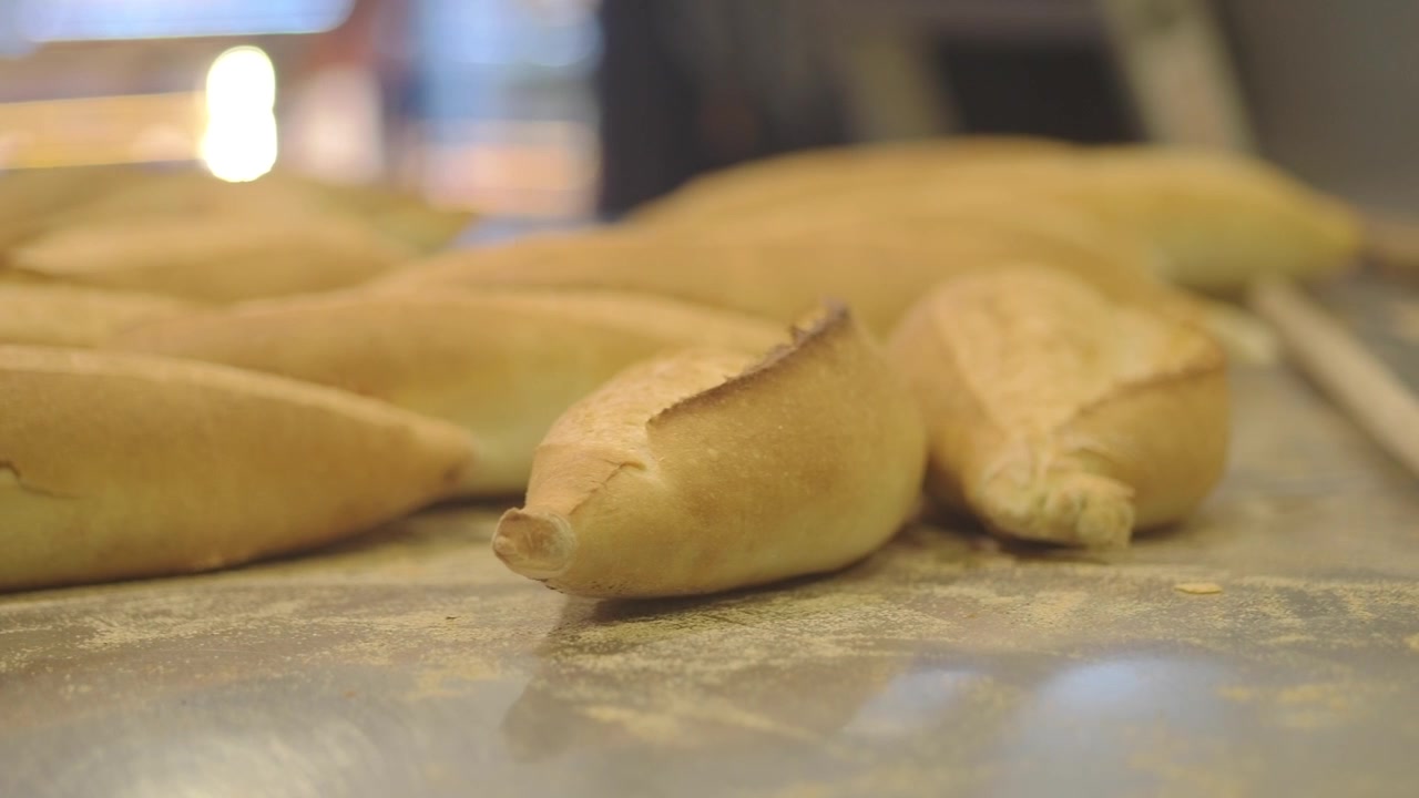 Pagnotte di pane appena sfornate su un bancone infarinato