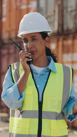 female worker communicating with radio at port