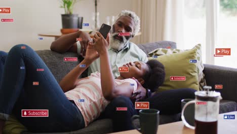 Animation-of-social-media-icons-and-networks-over-african-american-man-and-woman-with-tablet