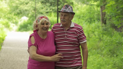 Pareja-Caucásica-Mayor-Caminando-En-El-Parque-Abrazándose.-Un-Anciano-Camina-Con-Una-Mujer.-Esposo-Esposa