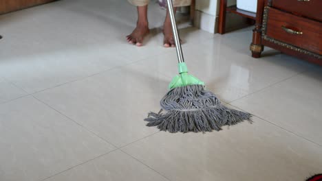 person mopping a tile floor