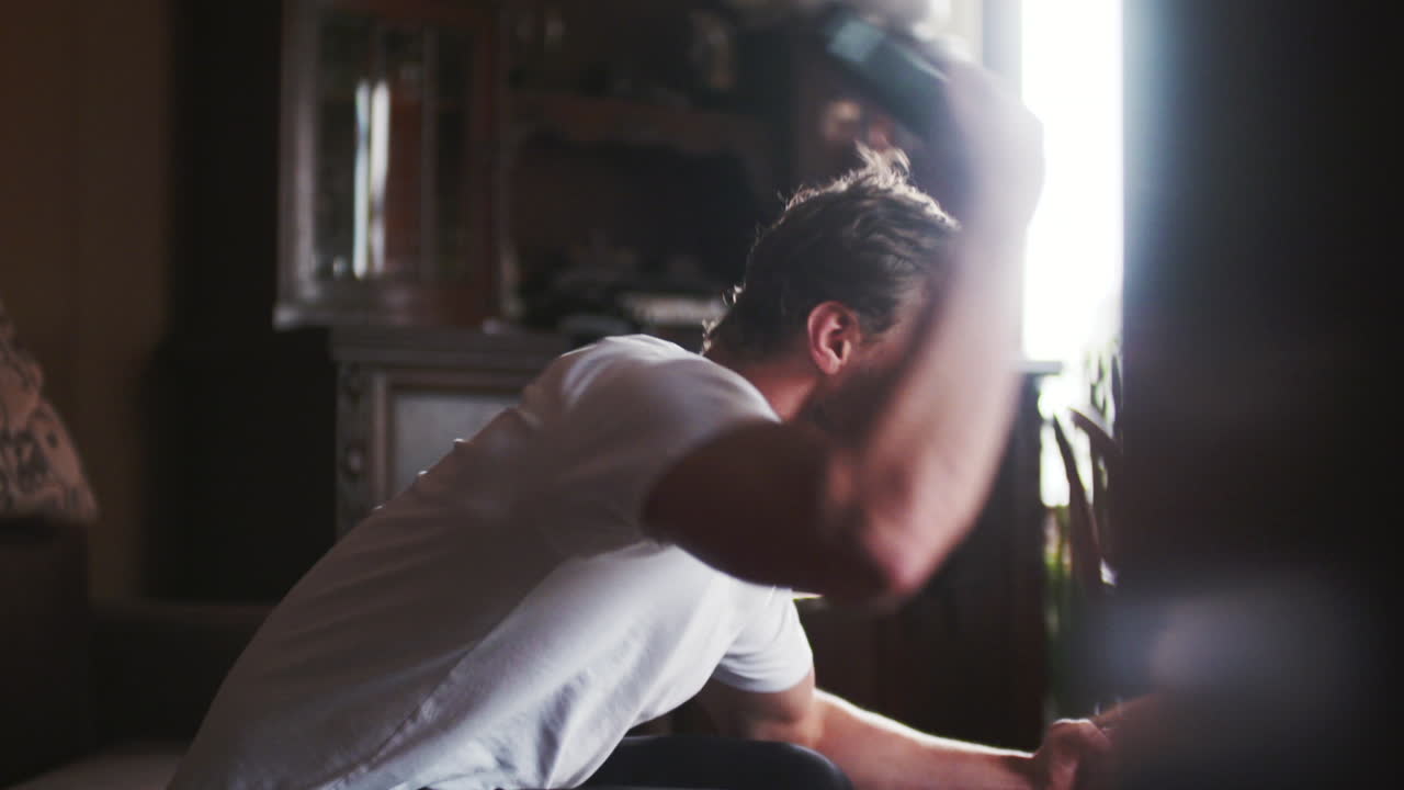 Giovane uomo che gioca ai videogiochi con un controller a casa
