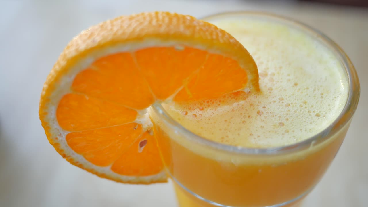 오렌지 조각과 함께 오렌지 주스 한 잔