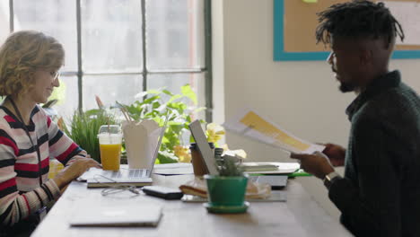 creative marketing team sharing project documents working together brainstorming ideas friends discussing strategy relaxing on lunch break in trendy modern office workplace