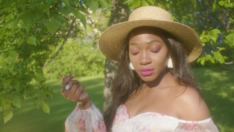 Black-Woman-adjusting-hair-on-picnic-in-park-looking-away-close-up