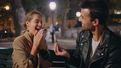 happy man giving ring making proposal in night park closeup. excited girl hug