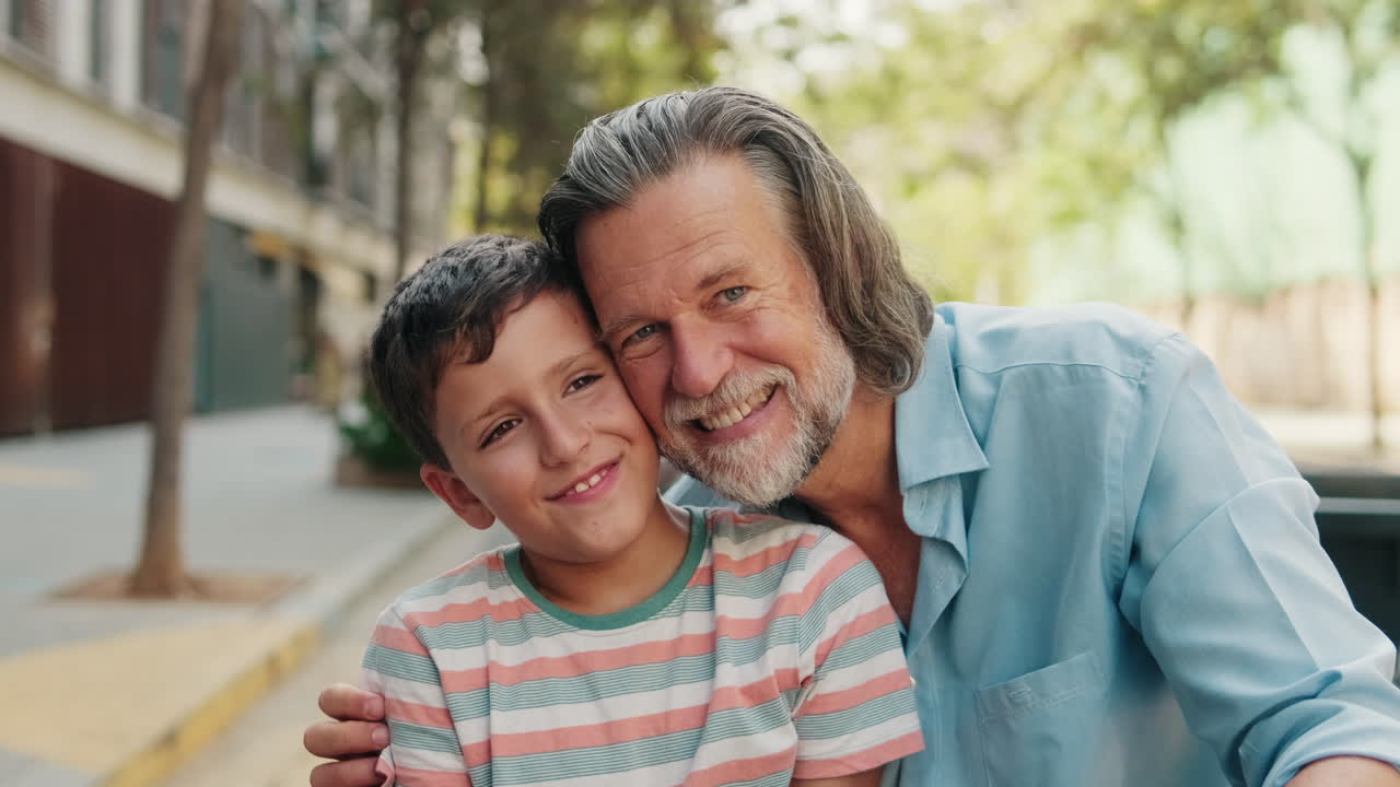 Avô e neto felizes se abraçando e sorrindo ao ar livre
