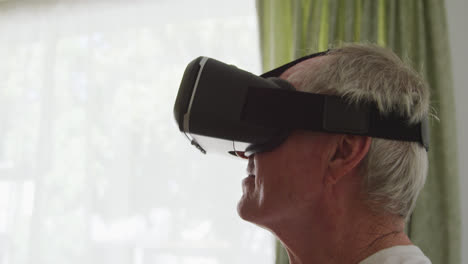 Senior-man-in-social-distancing-using-VR-headset